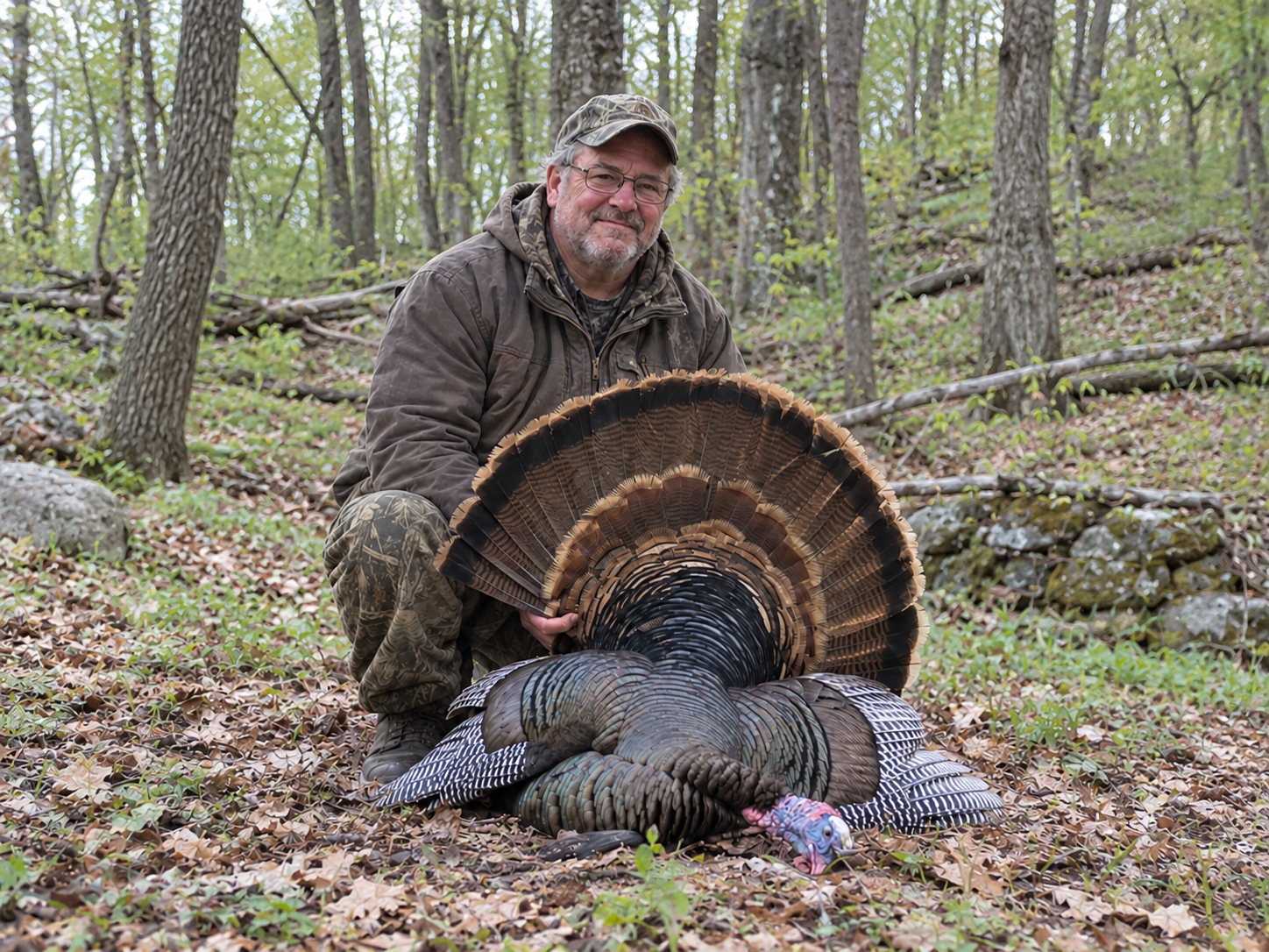 A successful turkey hunter holding a harvested tom